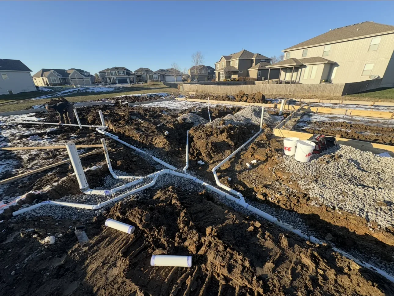 house, fence, snow, construction, pipes, dirt, blue sky